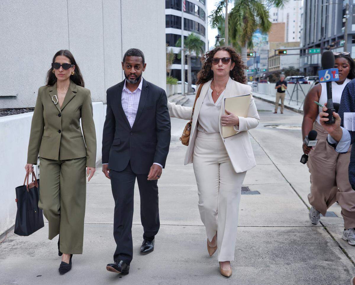 Corlie McCormick, center, the husband of Broward Congresswoman Sheila Cherfilus-McCormick, leaves the federal courthouse in Miami on Tuesday, Nov. 25, 2025, after she surrendered to authorities on charges of stealing a $5 million overpayment of federal disaster-relief funds to her family’s healthcare company. From left: attorney Melissa Madrigal, McCormick, and attorney Lauren Krasnoff, in white.