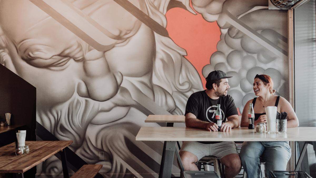 Diners enjoy a drink in front of the mural by artist CP1 at Square Pie City in the Design District.