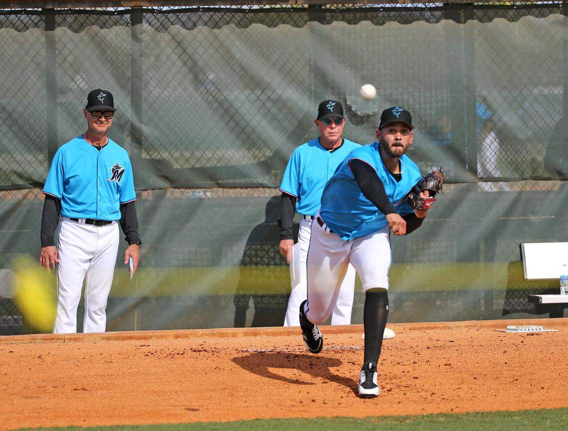 Miami Marlins pitcher Pablo Lopez (49) pitches as Marlins manager Don Mattingly (8) looks during the first full-squad spring training workout on Monday, February 18, 2019 in Jupiter, FL.
