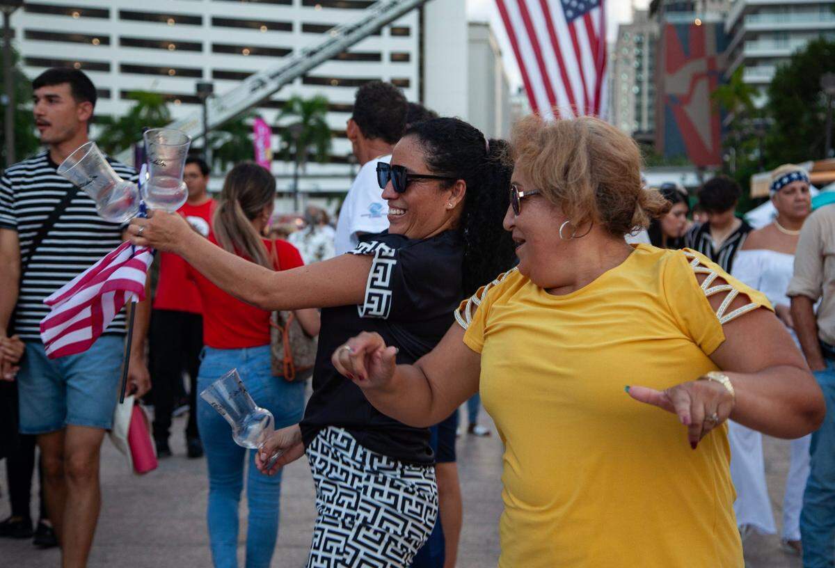 Sisters-in-law Diana Cruz (left) and Margarita Quijada (right) dance together during the Fourth of July Bayfront Park Celebration at Bayfront Park on Tuesday, July 4, 2023 in Miami, Fla.
