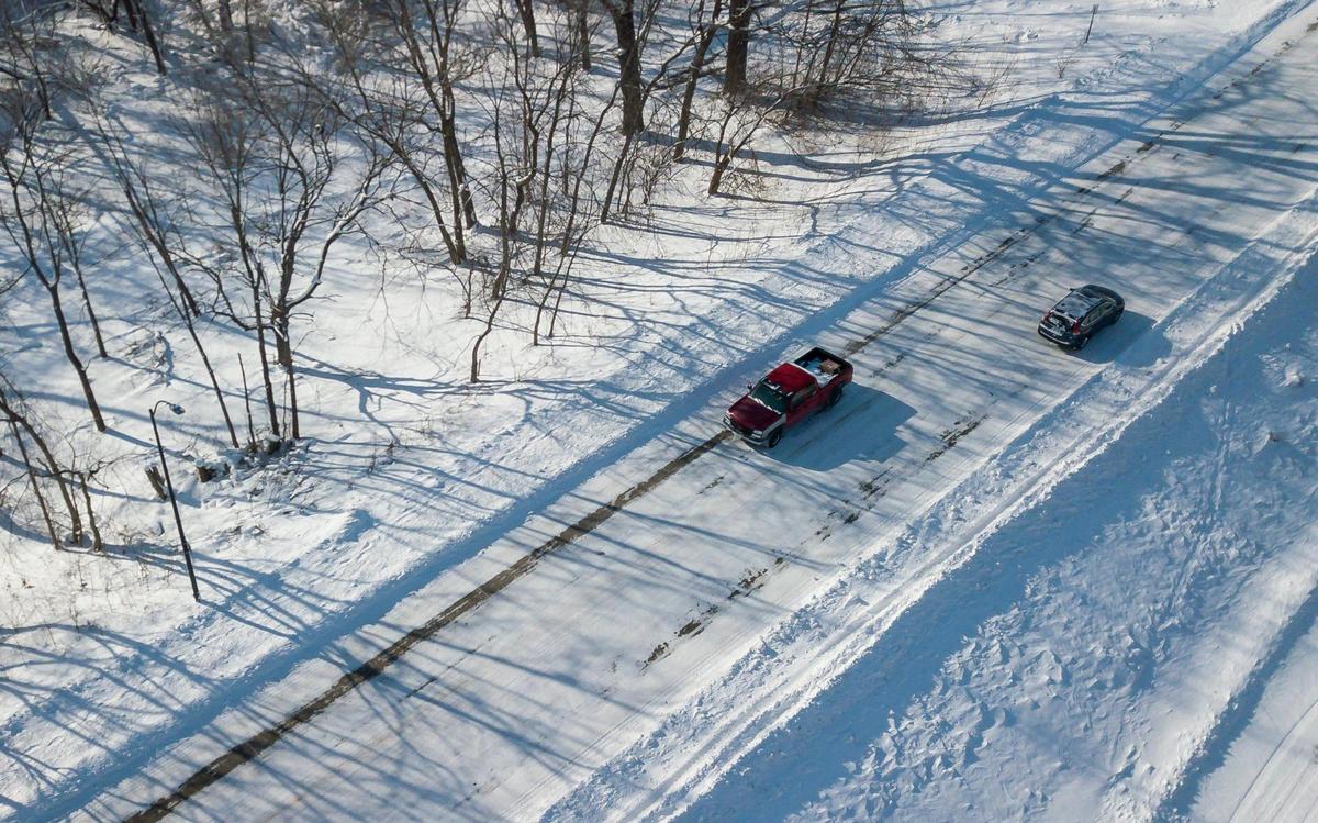 Cars drive through snowy conditions on Sunday, Jan. 14, 2024, in Ames, Iowa. Subzero temperatures have saddled the state ahead of the Iowa caucuses.
