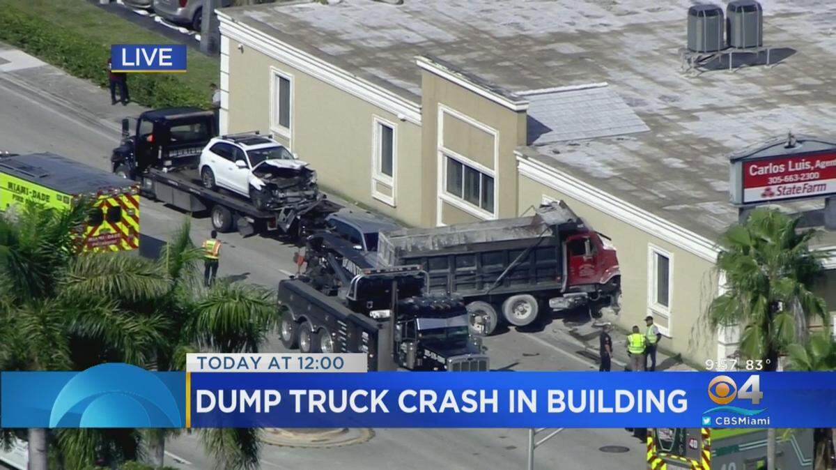 A CBS4 screen shot shows a dump truck wedged into a State Farm insurance office building along Bird Road and 60th Avenue in Southwest Miami-Dade on the morning of Nov. 8, 2019.