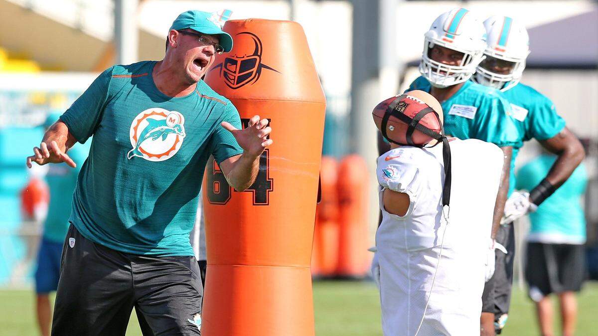 Miami Dolphins defensive line coach Kris Kocurek loudly instructs players during a drill in training camp late July.