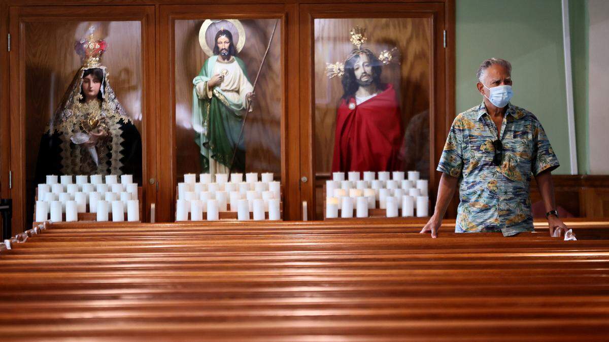 A churchgoer listens during Sunday Mass at St. Joseph’s Catholic Church in Miami Beach on June 27, 2021, three days after the building collapse.
