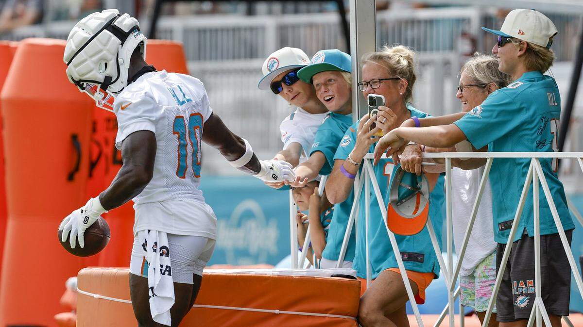 Miami Dolphins wide receiver Tyreek Hill (10) is greeted by fans during practice at the Miami Dolphins training facility in Miami Gardens, FL, on Thursday, August 1, 2024. 