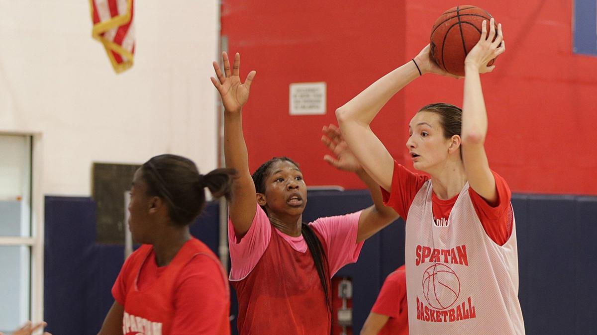 Koi Love (center) defends against Chantell Gonzalez, who is 6-foot-8, teammates at Miami Country Day School.
