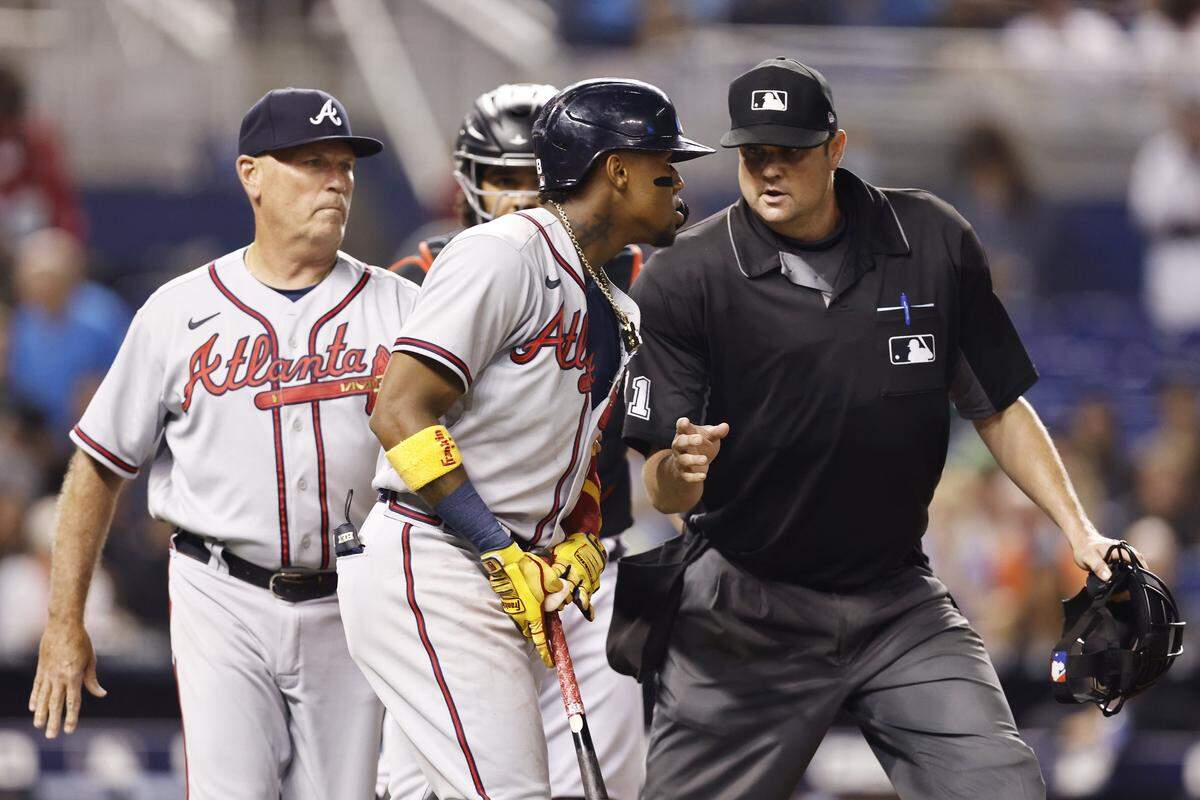MIAMI, FLORIDA - JULY 09: Ronald Acuna Jr. #13 of the Atlanta Braves is held back by umpire Jordan Baker #71 as he attempted to charge the mound after being hit by a pitch from Anthony Bender #80 of the Miami Marlins during the seventh inning at loanDepot park on July 09, 2021 in Miami, Florida. (Photo by Michael Reaves/Getty Images)