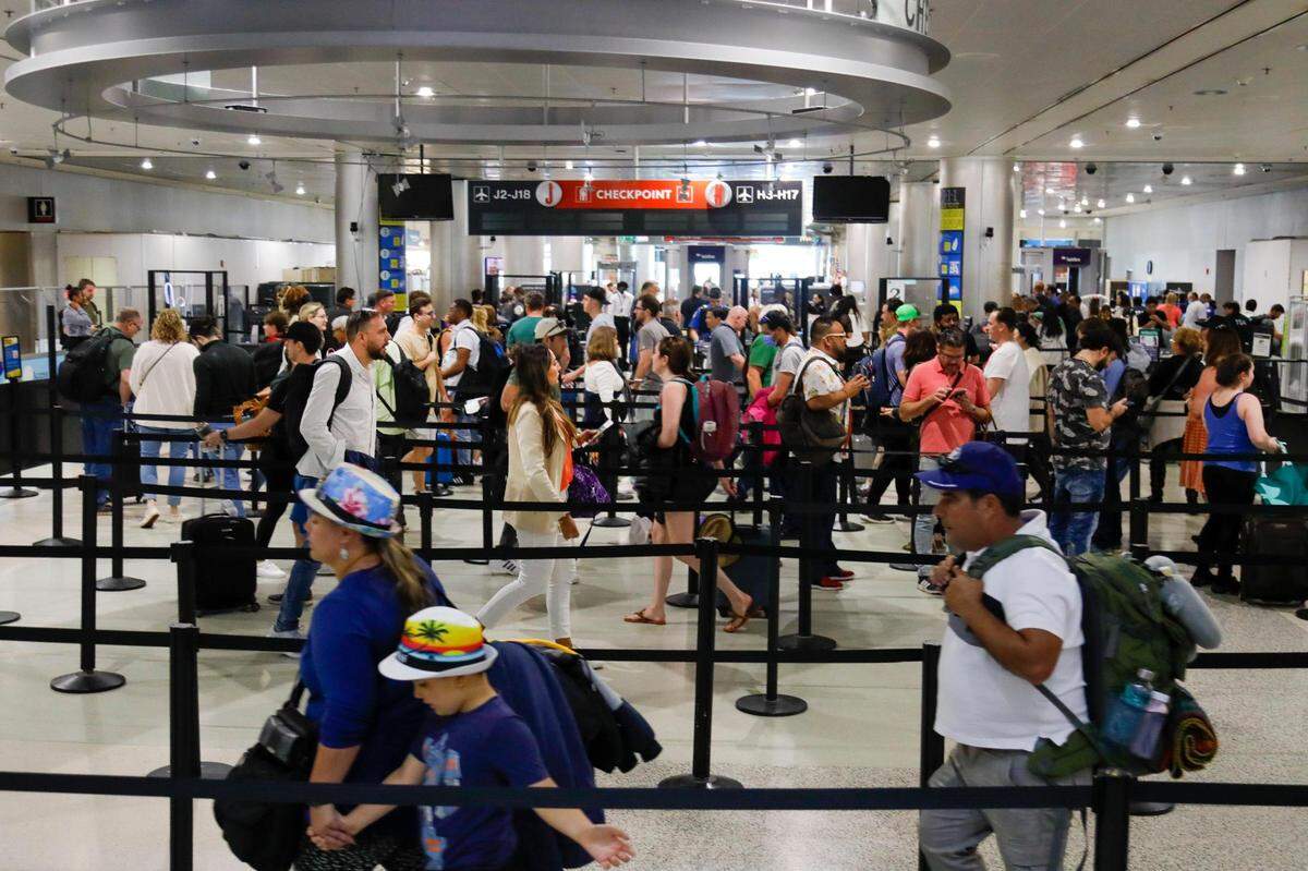 Passengers waiting in line to go through security at Miami International Airport on Monday, February 6, 2023