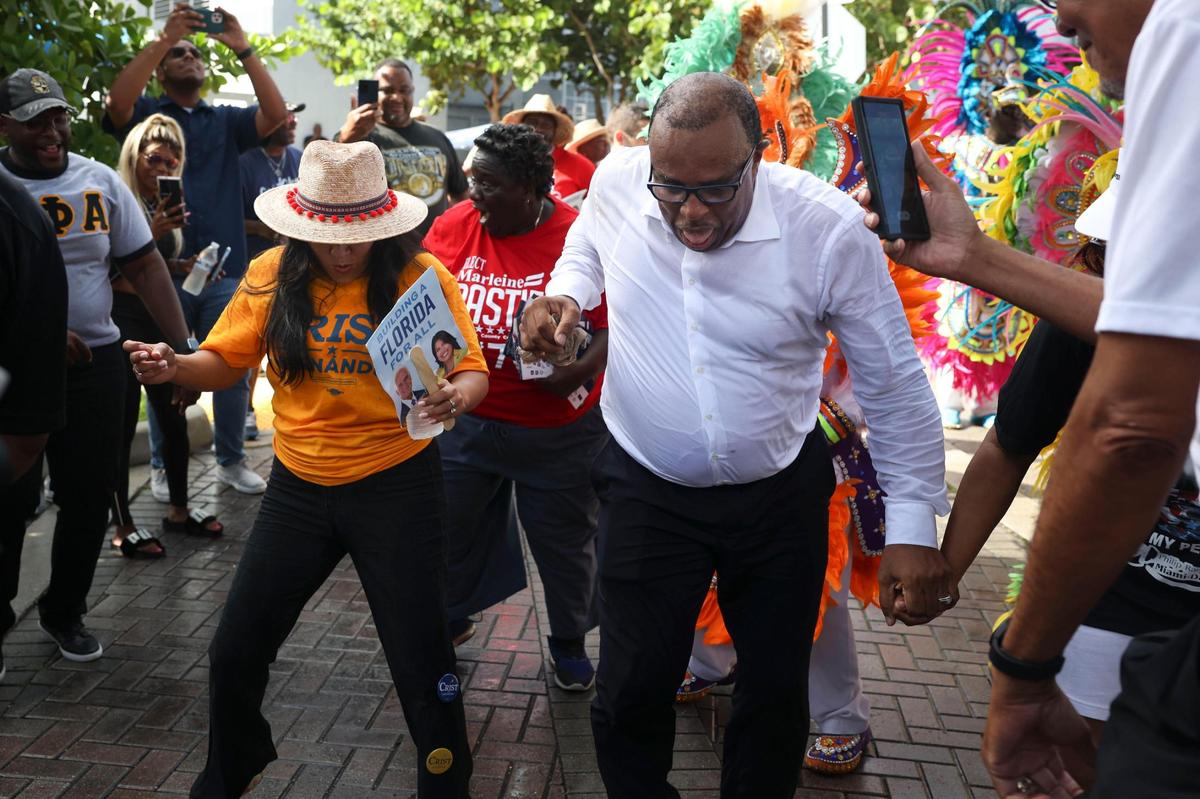 Karla Hernandez-Mats, running mate of Democratic gubernatorial candidate Charlie Crist, and Pastor Carl Johnson dance with the Junkanoo band during a Souls to the Polls event outside of the Joseph Caleb Center on Sunday, Nov. 6, 2022, in Liberty City, Miami.