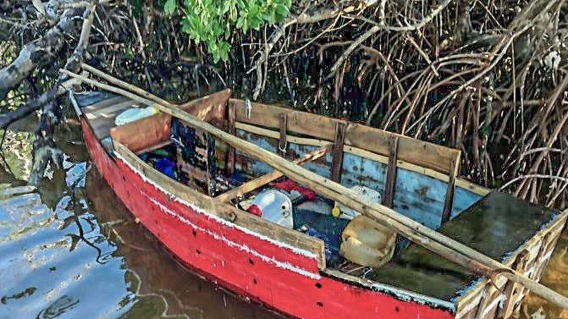 A red, wooden boat floats in the mangroves on the shores of the Middle Florida Keys city of Marathon Tuesday, Sept. 28, 2021. The U.S. Border Patrol says 10 men from Cuba were on the vessel.