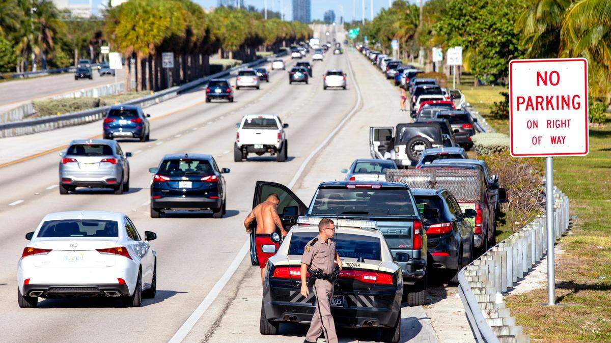 Florida Highway Patrol troopers ask drivers to move their cars from the shoulder of the Julia Tuttle Causeway in Miami in 2020.