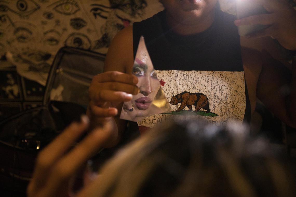 Persephone von Lips looks at herself (Henry Honest, holds mirror) at Gramps in Wynwood, where popular drag shows draw big crowds.