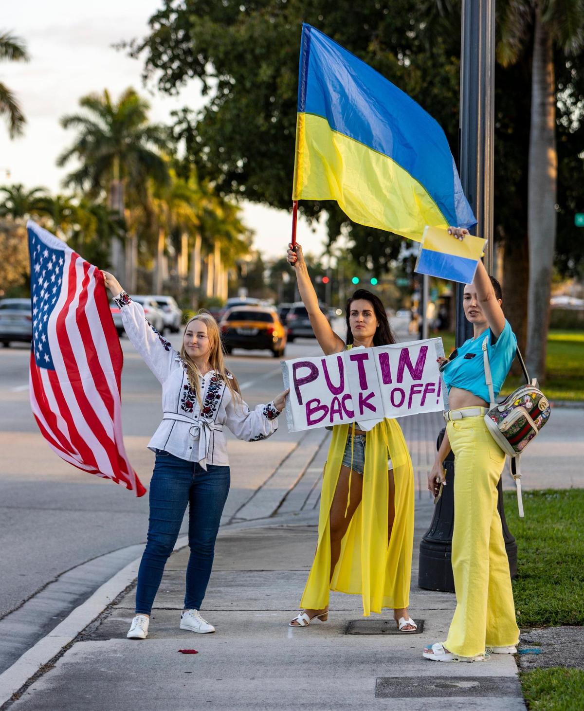 From left, Emilia Oliiar, Natalia Chernysh and Iryna Bezsmertna tell Russian leader Vladimir Putin what to do. On Feb. 24, 2022, members of the Ukrainian and Russian communities in South Florida gathered in front of Hallandale Beach City Hall in support of Ukraine after Russian forces invaded the country earlier in the day.