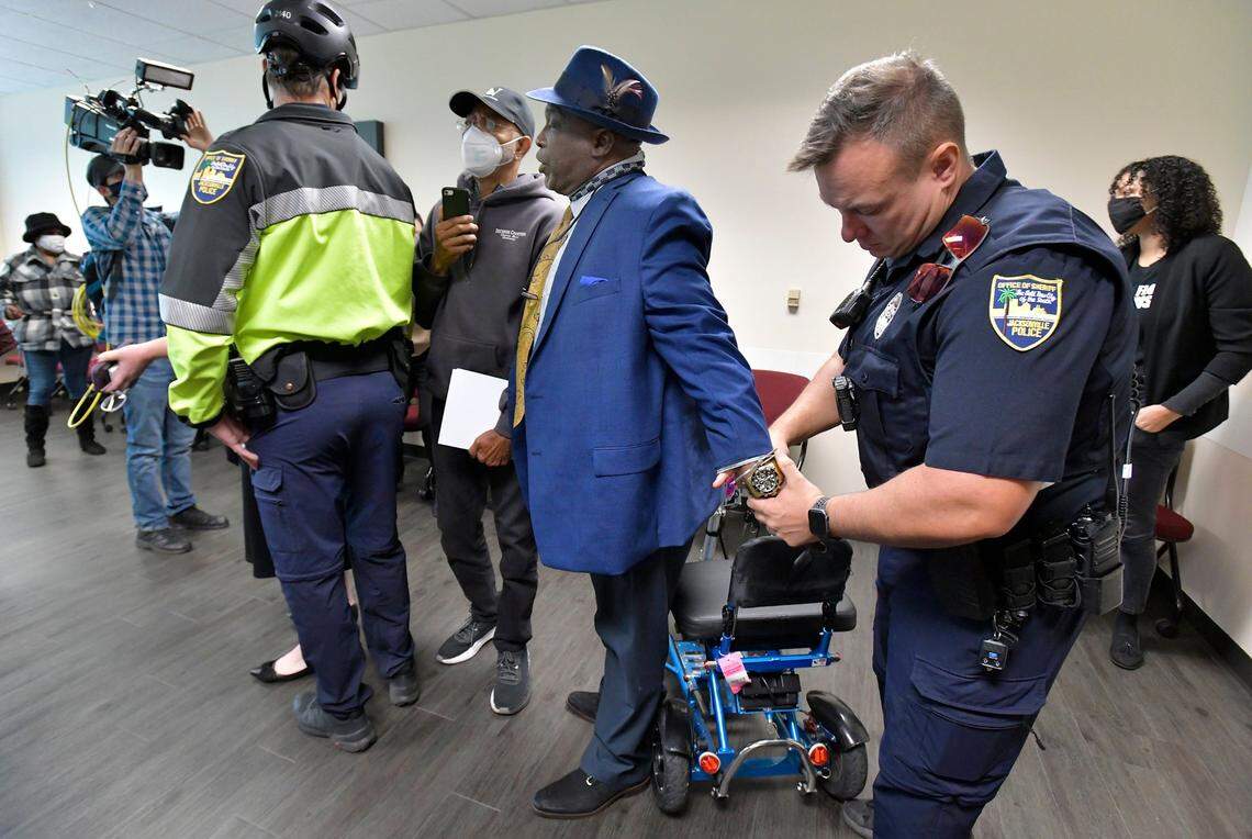 Ben Frazier, Jacksonville Northside Coalition founder, is handcuffed by a member of the Jacksonville Sheriff’s Office after refusing to leave the room where the press conference with the governor was to be held in Jacksonville, Fla., on Tuesday, Jan. 4, 2022. The planned press conference with Florida Governor Ron DeSantis was relocated from the Department of Children and Families office building to the adjacent FDLE building after protesters, wanting to address the governor refused to leave the initial press conference site.