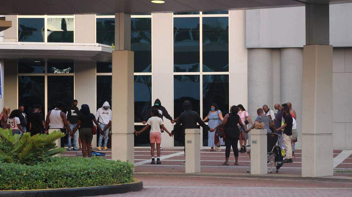 Friends and family of some of about two dozen people injured in a concert shooting in Miami-Dade County pray outside the Ryder Trauma Center at Jackson Memorial Hospital.