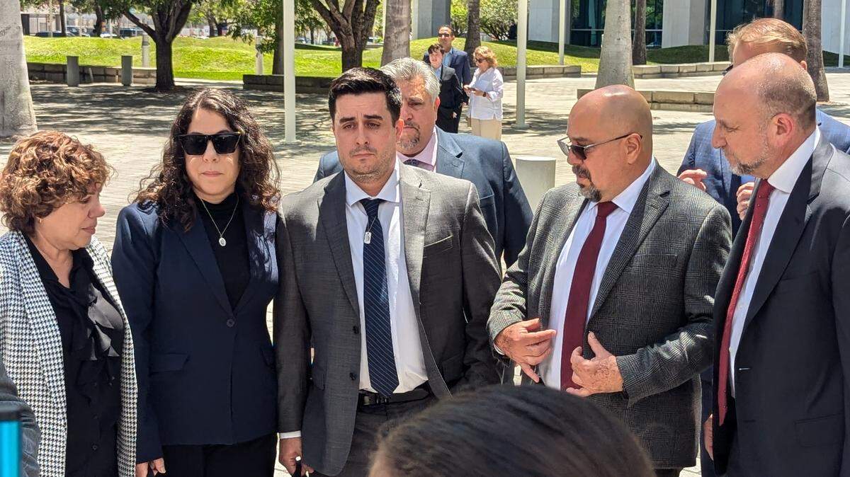 Dillon Angulo, center with tie, stands next to Neima Benavides, the sister of Dillon’s girlfriend Naibel Benavides Leon, who was killed in the Florida Keys crash in 2019 near the Ocean Reef Club. Angulo’s body was nearly shattered from the crash.