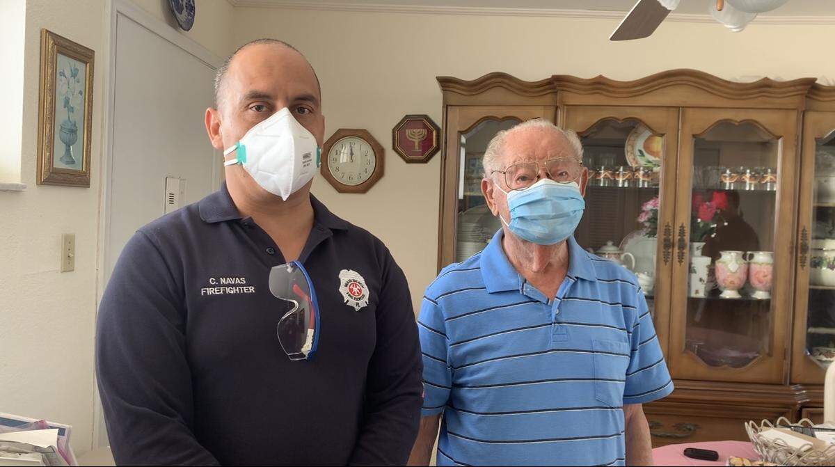 Miami Beach firefighter Claudio Navas stands with 95-year-old South Beach resident Saul Dymant after Navas vaccinated Dymant on Feb. 5, 2021.