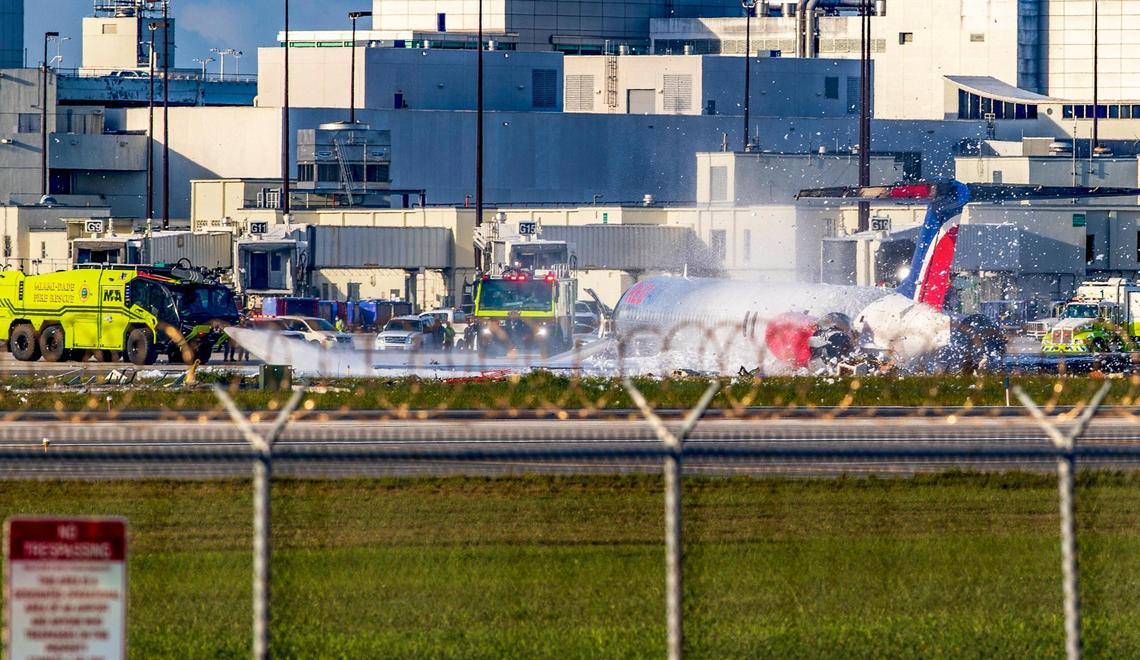 Fire units douse RED Air Flight 203 after it suffered a landing-gear malfunction, skidded on the runway and came to a stop on a grassy area on Tuesday. The flight was coming from the Dominican Republic.