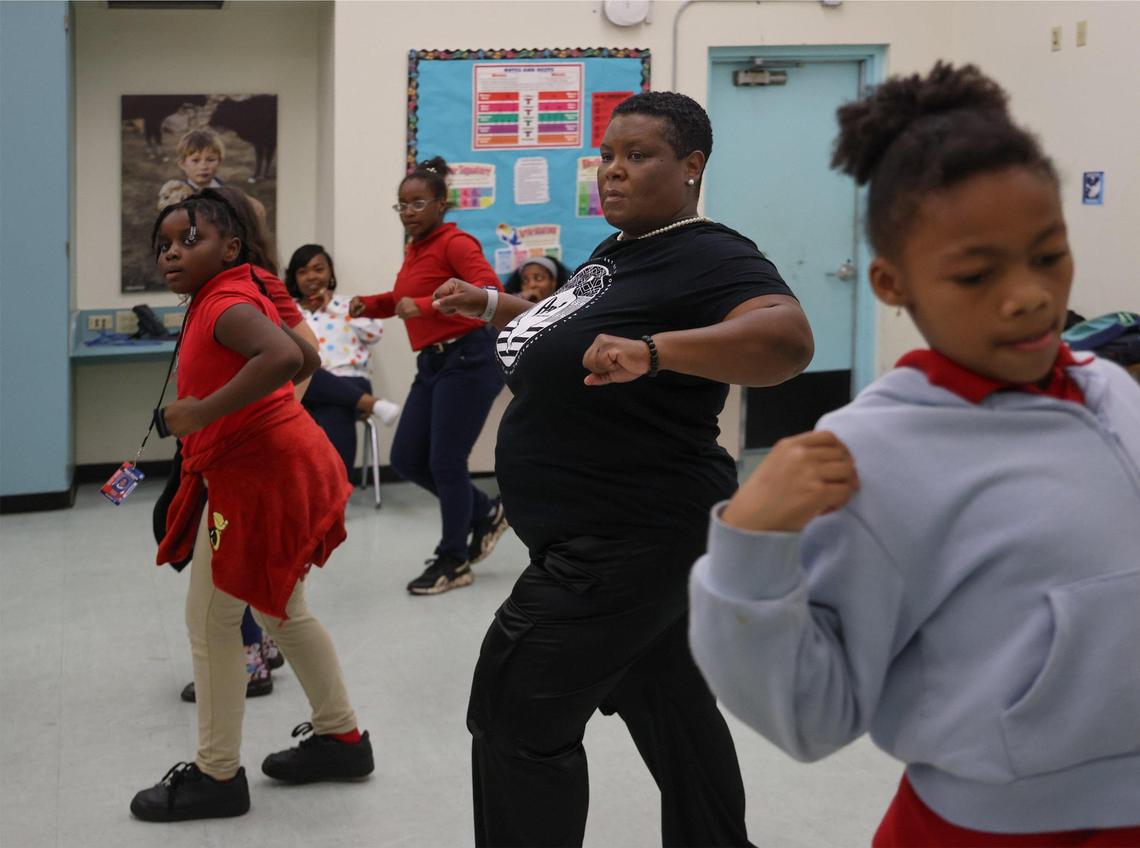Nakia Bowling, center, with Ten North Group, who founded an after-school program at Miami Shores Elementary learns some new steps along with children during a dance class.