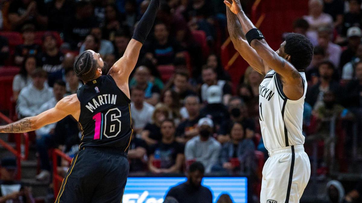 Brooklyn Nets guard Kyrie Irving (11) shoots over Miami Heat forward Caleb Martin (16) during the second quarter of an NBA game at FTX Arena in Downtown Miami, Florida, on Saturday, March 26, 2022.