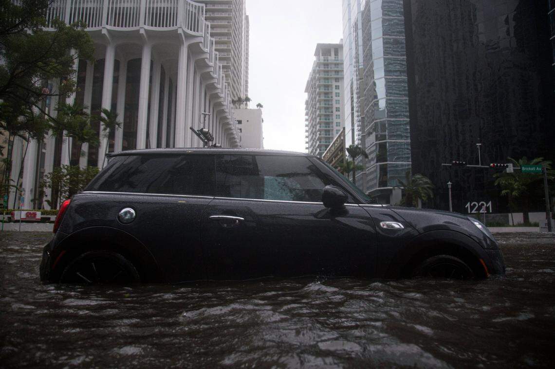 A MINI Cooper is seen abandoned on the flooded intersection of Southwest 13th Street and Brickell Avenue in Miami due to Tropical Storm Eta on Nov. 9, 2020.