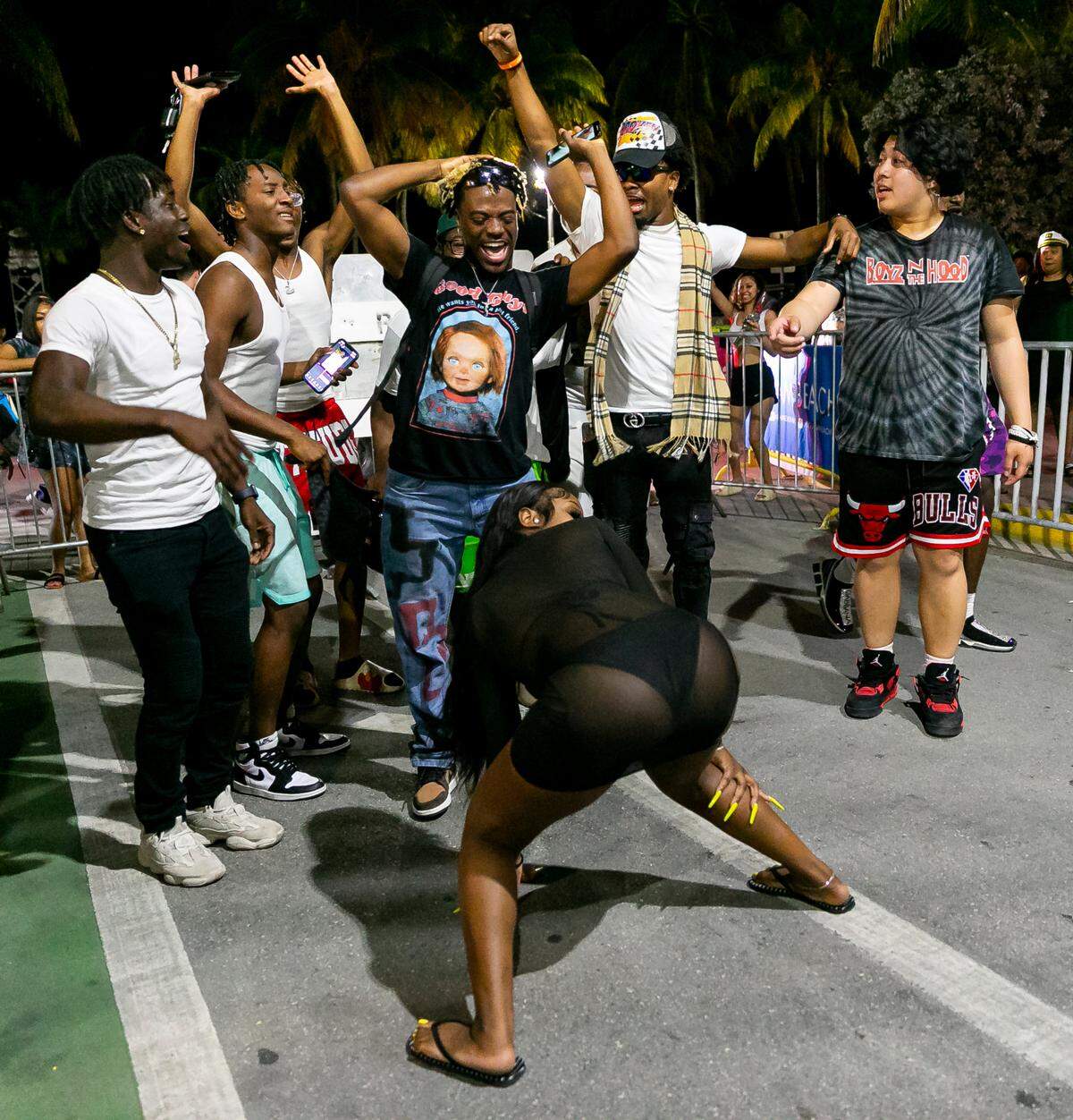 TikToker The Jiggy Prince, center, films a video on Ocean Drive and 8th Street as a crowd of people watch in Miami Beach, Florida on Friday, March 25, 2022. City officials imposed a midnight curfew and forced stores to stop selling alcohol after 6 p.m. The restrictions were set in place after two shootings in Miami Beach the weekend before caused city officials to announce a “state of emergency.”