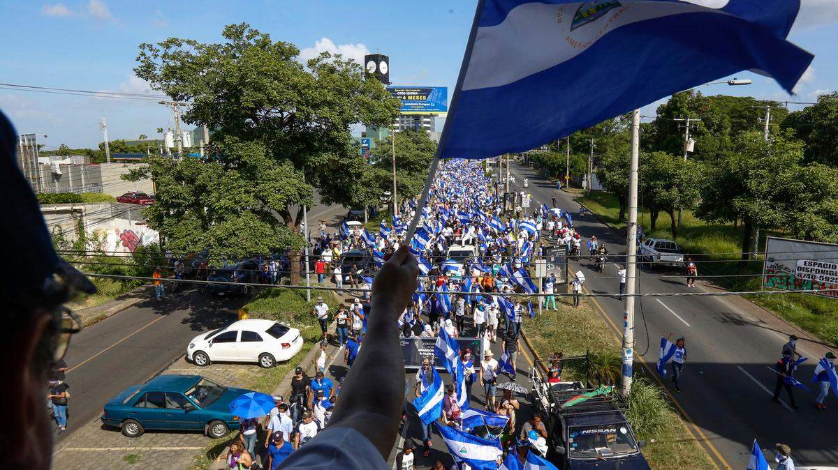 Protesters march on the street below during an anti-government protest in Managua, Nicaragua, Saturday, Aug. 11, 2018. The current unrest began in April, when President Daniel Ortega imposed cuts to the social security system and small protests by senior citizens were violently broken up. From then more than 300 people have died and demonstrators have demanded that Ortega leave power.