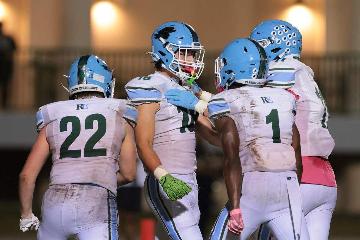 Ransom Everglades Juan Velazco (18) celebrates with running back Noah Alce (1) and outside linebacker Jack Mccarron (22) after scoring a touchdown against the Immaculata-La Salle during the first quarter of a Region 4-2A semifinal playoff game at Immaculata-La Salle High School on Friday, Nov. 21, in Miami, Fla.