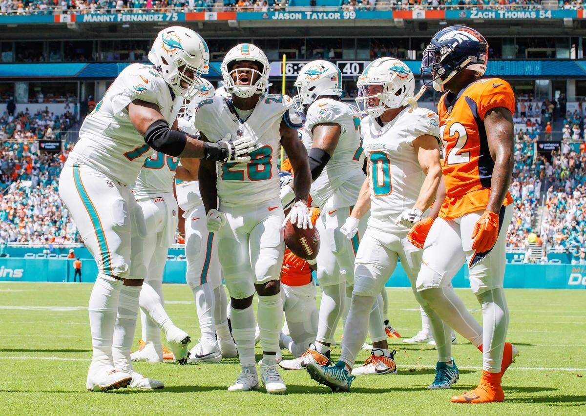 Miami Dolphins running back De’Von Achane (28) celebrates with teammates after scoring a touchdown against the Denver Broncos during first quarter of an NFL football game at Hard Rock Stadium on Sunday, Sept. 24, 2023 in Miami Gardens, Fl.