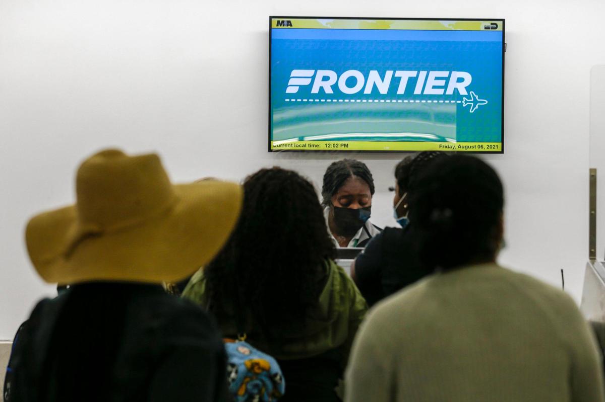 Travelers check in for their flights with Frontier Airlines at the ticket counter inside Concourse G at Miami International Airport on Friday, August 6, 2021.