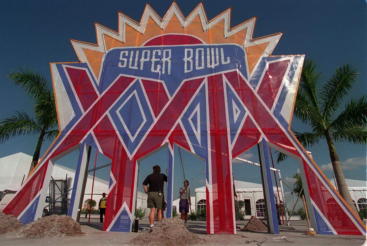 Palm trees flank workers outside Joe Robbie Stadium in Miami Saturday Jan. 28, 1995 as they adjust a Super Bowl XXIX sign in preparation for Sunday’s game between the San Diego Chargers and the San Francisco 49ers. (AP Photo/Beth A. Keiser)