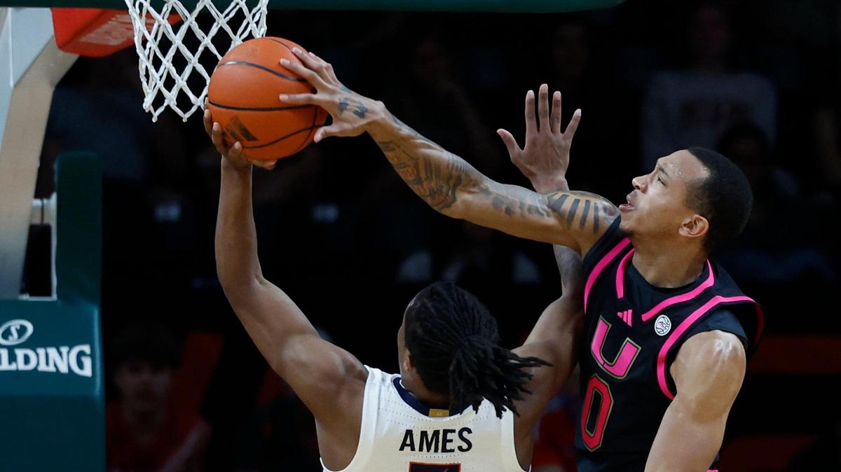 Miami Hurricanes guard Matthew Cleveland (0) blocks the ball as Virginia Cavaliers guard Dai Dai Ames (7) attempts a basket in the first half of their ACC basketball game at the Watsco Center in Coral Gables, Florida on Wednesday, January 29, 2025.