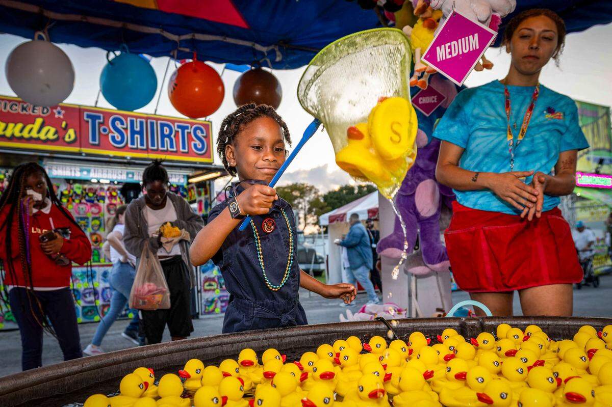 Tara Wells, 7, nets three ducks to win a prize at the Miami-Dade County Fair & Exposition