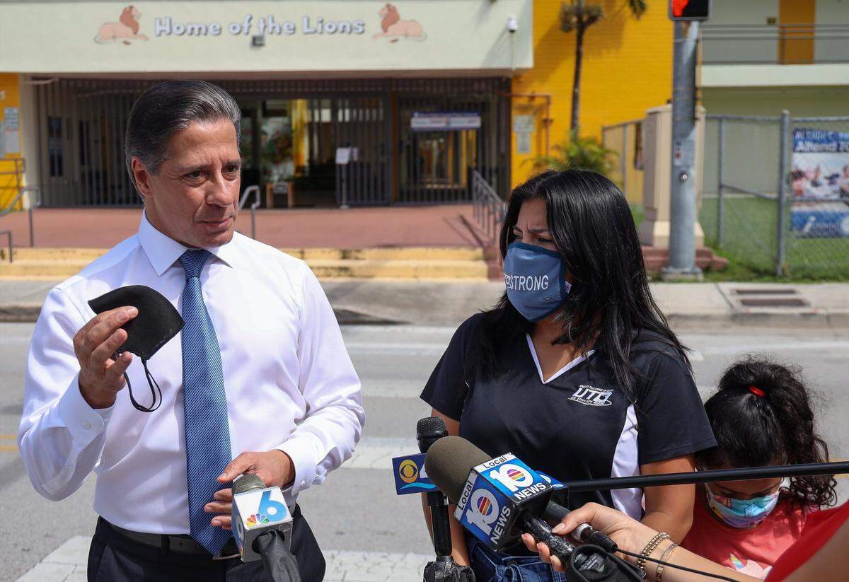 Miami-Dade County Public Schools Superintendent Alberto Carvalho, left, emphasizes the importance of mask wearing and vaccinating against COVID-19 as United Teachers of Dade President Karla Hernández-Mats and daughter, Naomi Mats, 7, standby he addresses the media Sept. 7, 2021.