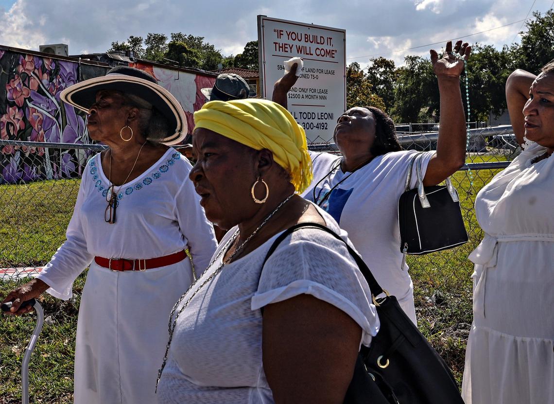 Parishioners of Notre Dame d’Haiti Catholic Church walk through the streets of Miami’s Little Haiti neighborhood past a sign announced a new real estate development during the traditional Good Friday procession in April.