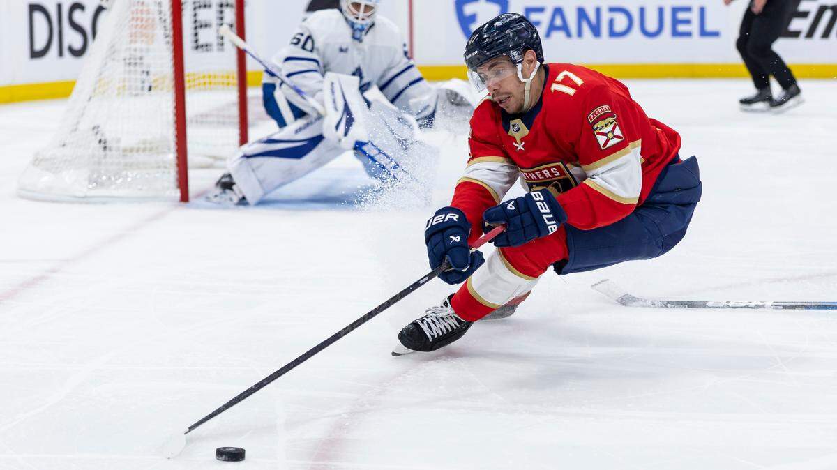 Florida Panthers center Evan Rodrigues (17) skates with the puck as Toronto Maple Leafs goaltender Joseph Woll (60) defends his post in the third period of Game 3 of a second-round Stanley Cup playoffs series at the Amerant Bank Arena on Friday, May 9, 2025, in Sunrise, Fla.