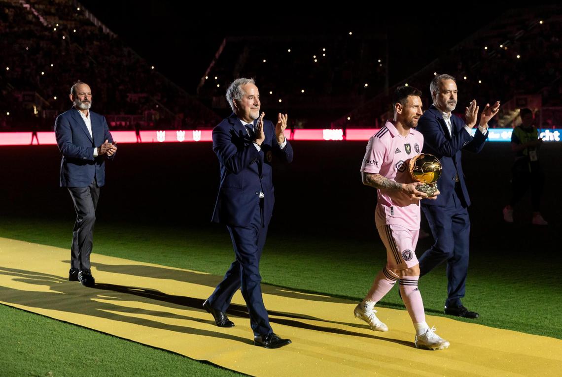 Inter Miami forward Lionel Messi (10) holds the Ballon d’Or during the opening ceremonies of his Noche d’Or soccer match against NYCFC at DRV PNK Stadium on Friday, Nov. 10, 2023, in Fort Lauderdale, Fla. From left to right: MLS Commissioner Don Garber, Inter Miami Co-owner Jorge Mas, Lionel Messi and Inter Miami Co-owner Jose Mas.
