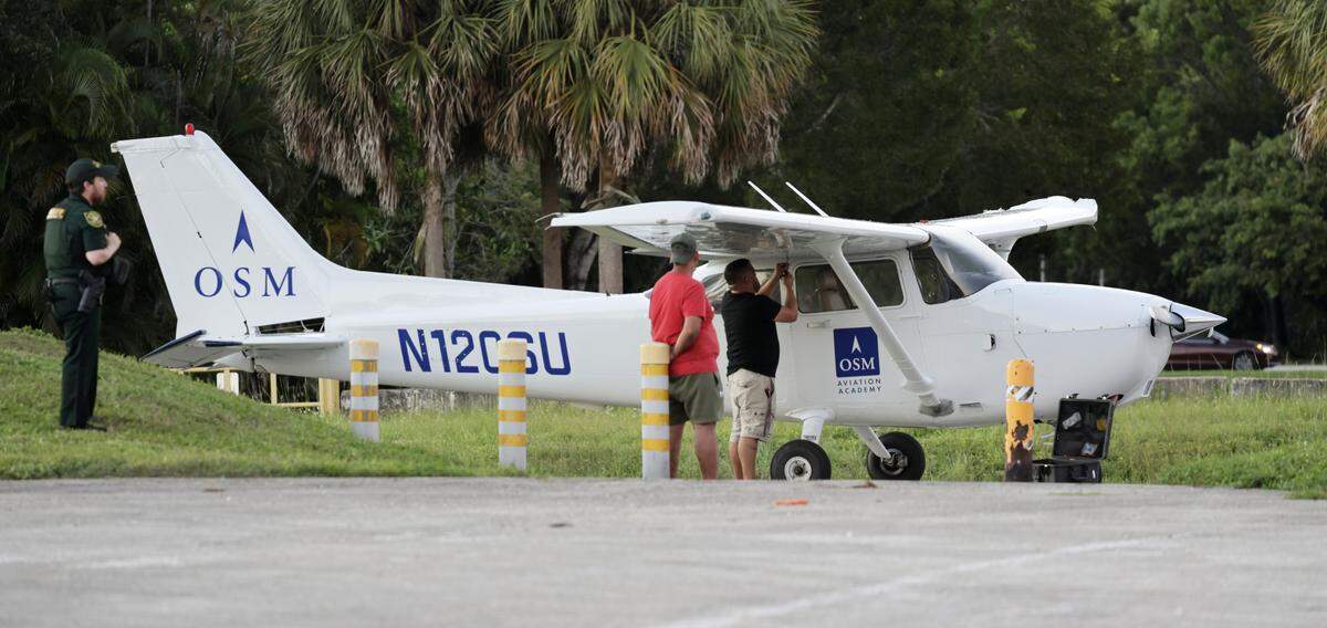 A man works on fixing a small plane that made an emergency landing near the Cypress Creek Canal in North Lauderdale on Monday, Oct. 13, 2025. (Carline Jean/South Florida Sun Sentinel)