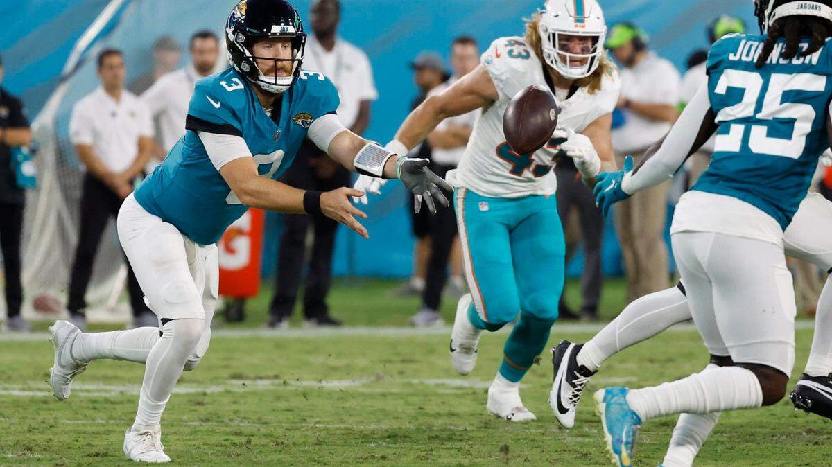 Jacksonville Jaguars quarterback C.J. Beathard (3) tosses the ball to Jacksonville Jaguars safety Ayo Oyelola (35) as Miami Dolphins linebacker Andrew Van Ginkel (43) defends in the first half at EverBank in Jacksonville, Florida on Saturday, August 26, 2023.
