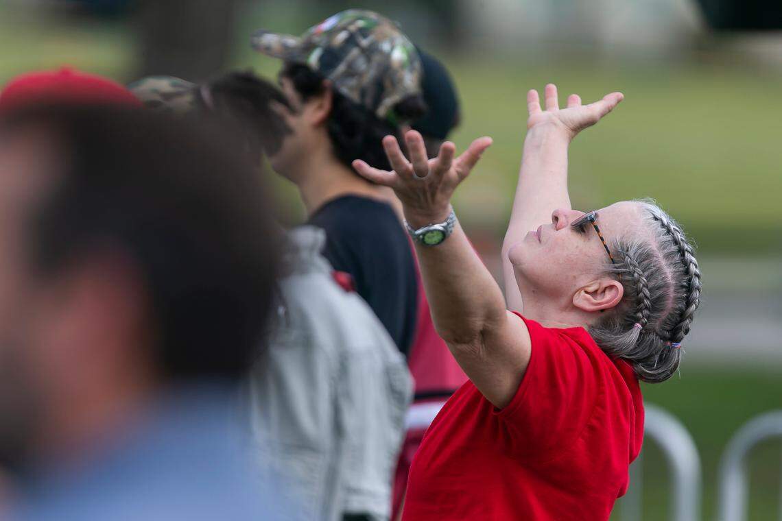 A Mike Pence and Donald Trump supporter prays before the start of a campaign rally near the Cuban Memorial Monument in Tamiami Park on Thursday, Oct. 15, 2020 in Miami, Florida.