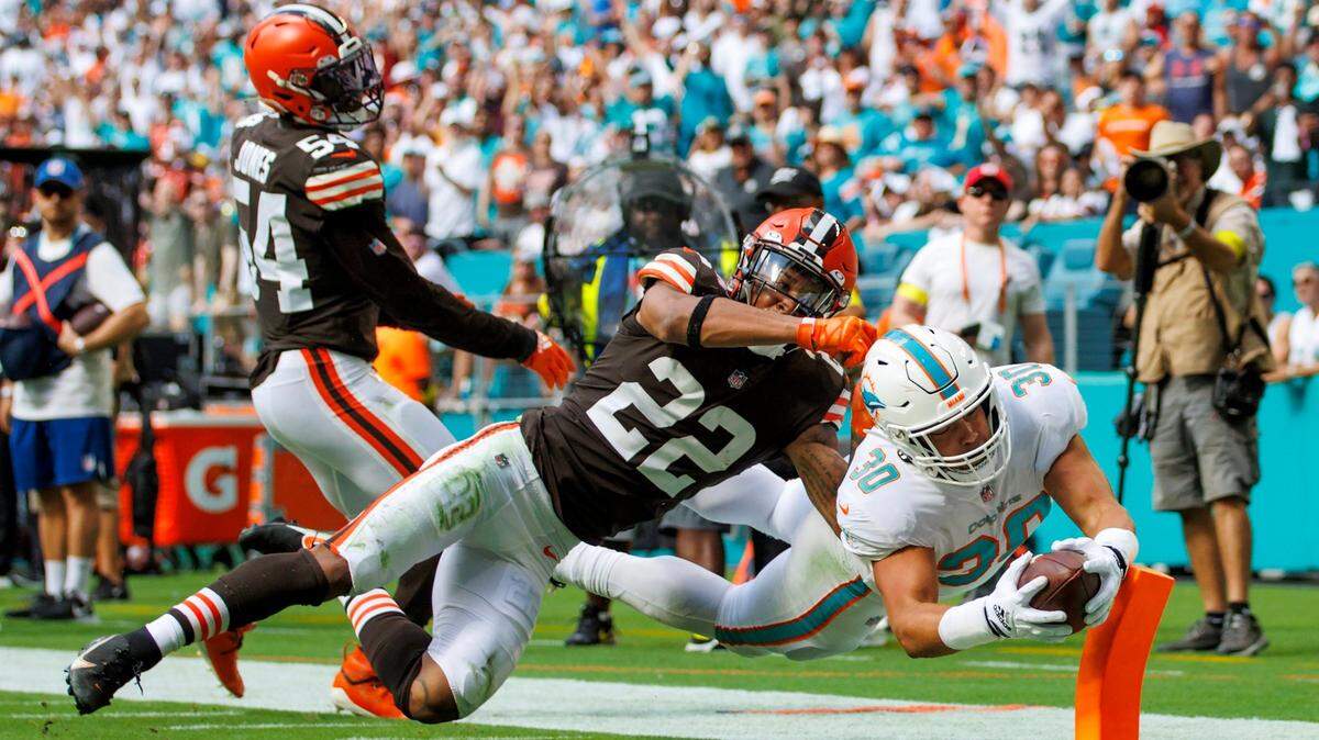 Miami Dolphins fullback Alec Ingold (30) scores a touchdown against the defense of Cleveland Browns safety Grant Delpit (22) during first quarter of an NFL football game at Hard Rock Stadium on Sunday, November 13, 2022 in Miami Gardens, Florida.