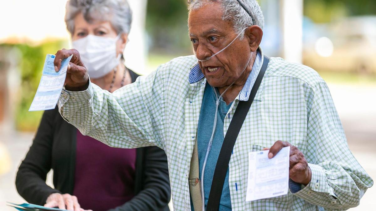 Juan A. Salazar, de 77 años, residente de Haley SOFGE Towers, explica cómo su afiliación política fue cambiada de demócrata a republicana sin su consentimiento mientras sostenía sus tarjetas de registro de votante. La senadora de Florida, Annette Taddeo, habló sobre las afirmaciones de cambios en la afiliación de votantes durante una conferencia de prensa frente a Haley SOFGE Towers en el vecindario de Little Havana de Miami el viernes 11 de febrero de 2022.