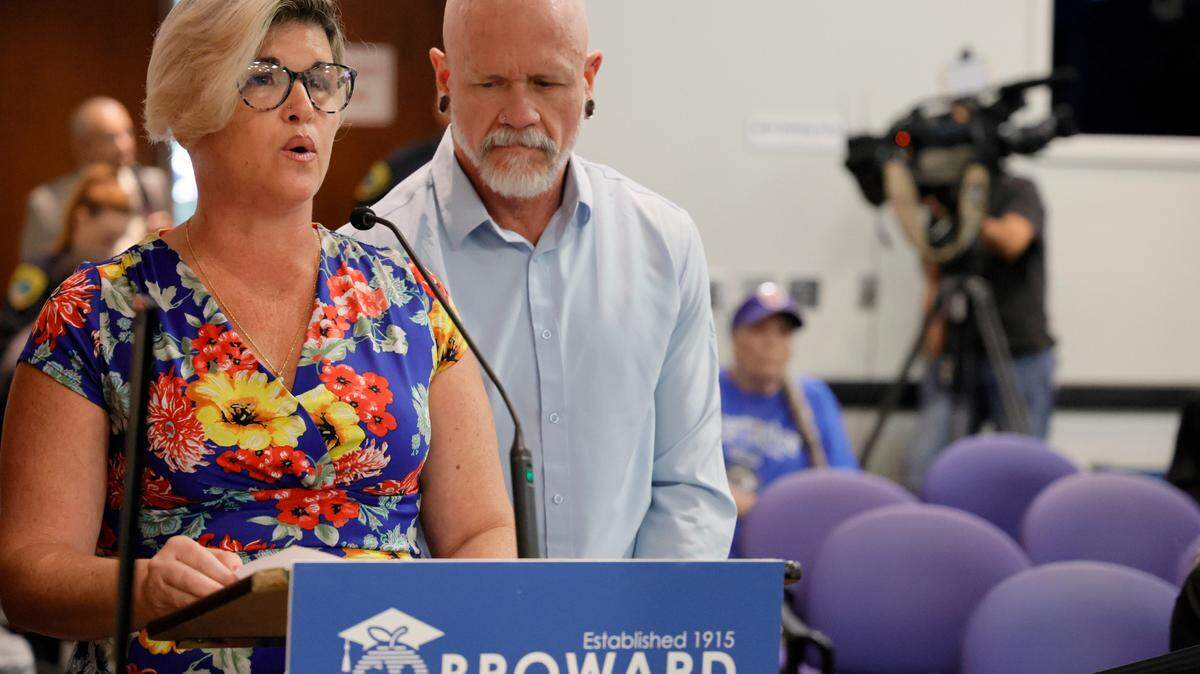 Jessica Norton, with her husband, Gary, speaks during the public comment period at a Broward County School Board meeting in Fort Lauderdale held on Tuesday, June 18, 2024. Norton, whose daughter played on the Monarch High School volleyball team, was one of five Monarch officials removed from the school Nov. 27 amid an inquiry into possible violations of the “Fairness in Women’s Sports Act,” a 2021 law that bans transgender girls from playing on girls’ sports teams. Norton is the only one facing potential discipline. (Amy Beth Bennett / Sun Sentinel)