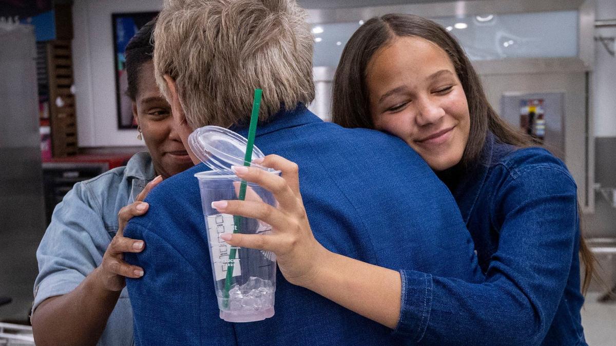Victoria Jones, right, hugs her grandfather, Walter Stocker, as Carime Torres, left greets her father at the International arrivals terminal at Miami International Airport. Mr. Stocker flew to Miami aboard an American Airlines flight from Port-au-Prince, Haiti.
