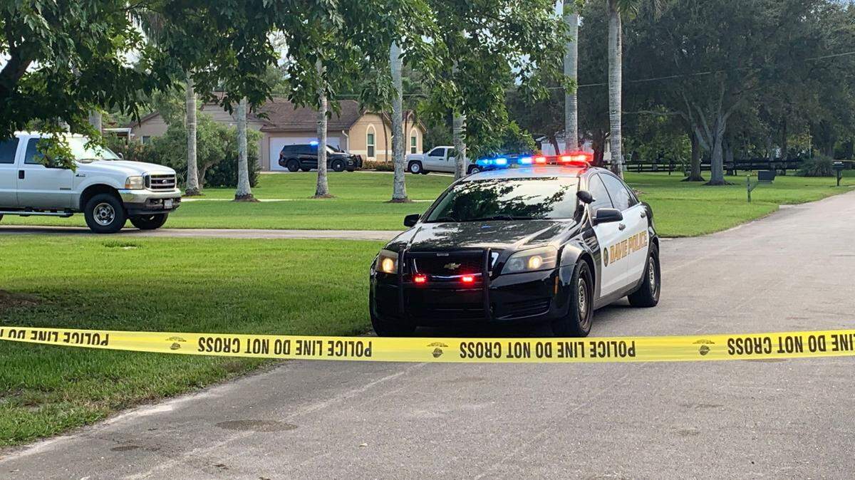 A Davie police car sits in the 14600 block of Southwest Eighth Court in front of a brown home, where a father shot and killed his dying daughter and then shot and killed himself on Monday morning, Davie police say.