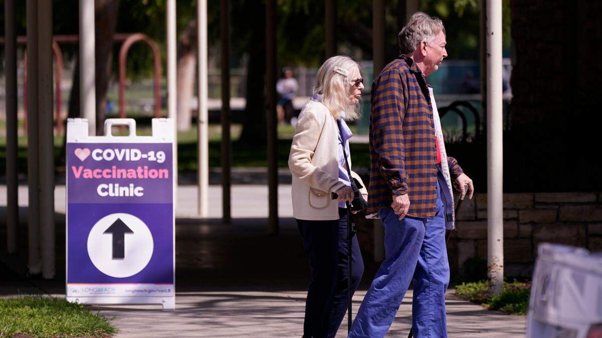 People leave a testing and vaccination clinic for COVID-19 Wednesday, March 30, 2022, in Long Beach, Calif.