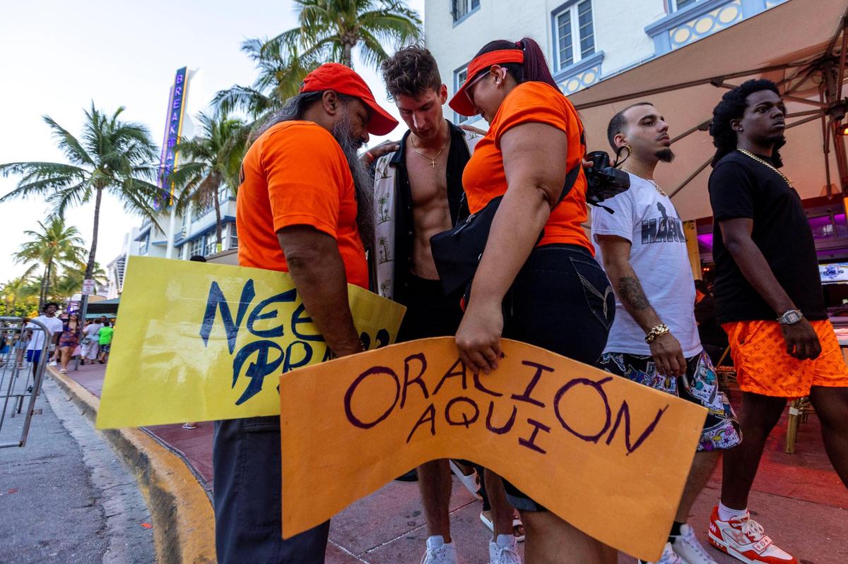 God Squad members pray along with Pittsburgh native Chris Trzicina, 28, for his family and friend who has seen combat, during Memorial Day weekend at Miami Beach, Florida, on Sunday, May 28, 2023.