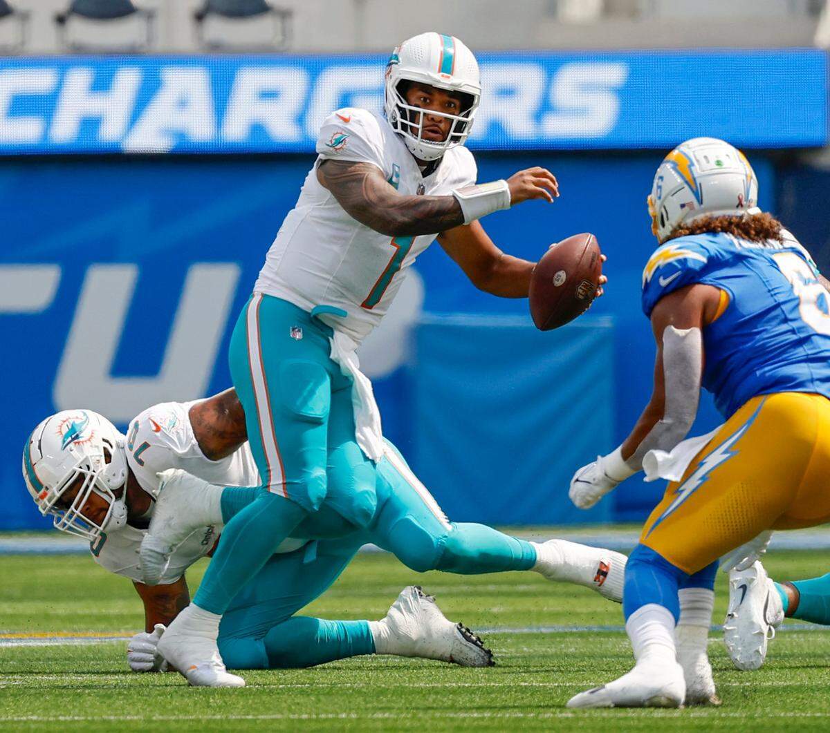 Miami Dolphins quarterback Tua Tagovailoa (1)looks to pass as Los Angeles Chargers linebacker Eric Kendricks (6) defends during first quarter of an NFL football game at SoFi Stadium in Inglewood, California on Sunday, September 10, 2023.