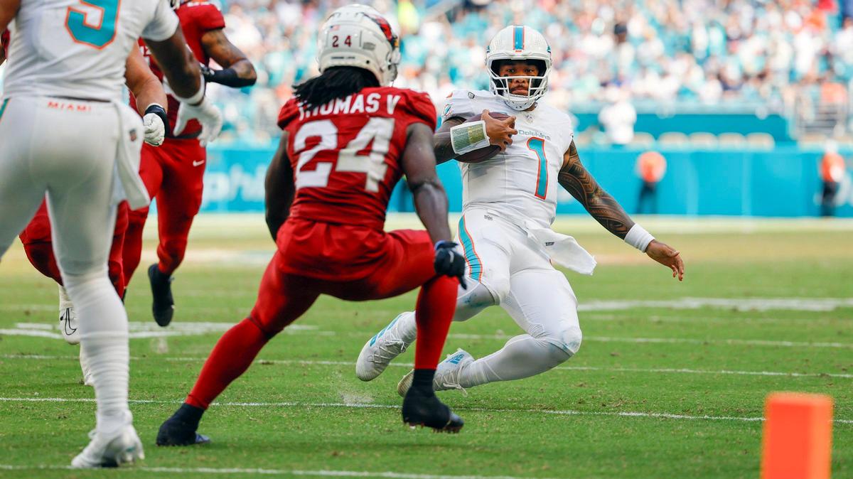 Miami Dolphins quarterback Tua Tagovailoa (1) slides after scrambling inside the ten yard line as Arizona Cardinals cornerback Starling Thomas V (24) defends in the second half during an NFL football game at Hard Rock Stadium in Miami Gardens, Florida on Sunday, October 27, 2024.