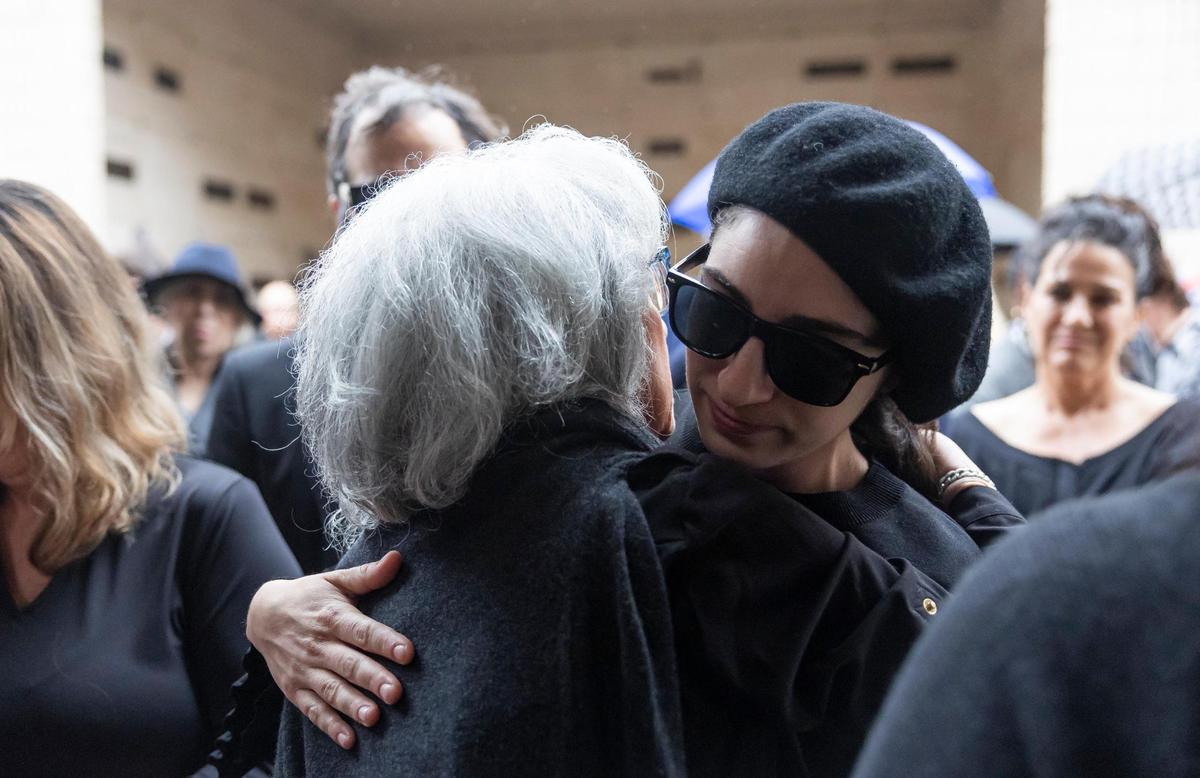 Joyce Moore, left, wife of the late Sam Moore, hugs Emily Estefan during his funeral service at Lakeside Memorial Park and Funeral Home on Friday, Jan. 17, 2025, in Doral, Fla. Moore, the R&B singer from the famed 1960s duo Sam & Dave, died on Friday, Jan. 10, at the age of 89.